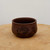 Unglazed chocolate brown pot with a hand-etched design