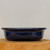 Side view of the dark blue glazed Yixing pot on a natural wood slice