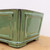 Side angle close-up of the glazed Yixing pot in muted sage green