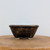 Small rectangular handmade bonsai pot by Andy Arnault, No. 531, on a light wood slice