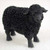 A miniature black sheep figurine intended as a decorative accent for bonsai tree displays. The figurine is depicted in a standing position, completely finished in a uniform matte black color. Its wool is characterized by a distinctive, deeply textured, and porous surface, while the face and legs have a smoother finish with fine details. This small-scale animal figure is ideal for creating a miniature pastoral scene within a container garden or bonsai arrangement.