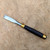 Single heavy duty Tinyroots wood chisel resting on a natural wood stump