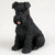 Miniature solid black Schnauzer figurine with uncropped ears, in a seated pose