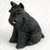 A charming and detailed figurine of a black Miniature Schnauzer, designed as a decorative accessory for a bonsai tree arrangement. The small black dog is captured in a sitting position, looking slightly to its left. Its signature breed characteristics are meticulously sculpted, including its thick, wiry coat, bushy eyebrows, and iconic beard. A tiny, bright pink tongue playfully peeks out from its mouth, adding a touch of personality. The figurine is set against a soft, light-colored background that emphasizes its dark color and intricate textures. This schnauzer black bonsai tree figurine is perfect for adding a whimsical and personal touch to a miniature garden or indoor bonsai display.