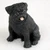 Miniature black pug figurine sitting upright and alert, a bonsai accessory