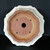 Underside of the cream pot showing a square stamp and drain hole