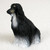 A small, detailed bonsai tree figurine of an Afghan Hound, depicted in a sitting position and facing to the left in profile. This miniature decorative statue captures the elegant and refined silhouette characteristic of the breed, featuring a long, flowing coat that appears to drape gracefully to the ground. The figurine is meticulously painted with a striking black and white color scheme; the upper portion of the dog's head, ears, and back is a deep matte black, which seamlessly transitions into a silvery-white or light grey towards the bottom, mimicking the appearance of light-colored fur on its legs and tail. The texture of the figurine is finely detailed, with etched lines representing the individual strands of long, silky hair. Designed as an accessory for a miniature garden or bonsai display, this black and white Afghan Hound figurine adds a touch of personality and artistic detail to any indoor botanical arrangement.