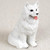 A detailed miniature Samoyed dog figurine, designed as a charming accessory for a bonsai tree arrangement. The small white dog is sculpted in a sitting position, looking slightly upward with an alert and friendly expression. The figurine features a highly textured surface that realistically mimics the dense, fluffy white coat characteristic of the Samoyed breed. Its small black eyes and nose contrast sharply with its pristine white fur, and a tiny pink tongue peeks out from its mouth, giving it a playful appearance. This decorative dog statue is perfect for adding a touch of personality and life when placed at the base of a miniature bonsai scene.
