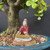 Chinese figurine of a woman on a tan rug playing a koto harp