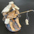 Chinese mud man fisherman figurine seated on a dark textured rock, F-008