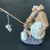 Chinese fisherman figurine seated on a dark craggy rock base