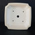 Recessed base of the cream square pot with five drainage holes