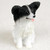 Miniature black and white Papillon figurine sitting upright with butterfly ears