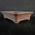 Angled view of the pot's carved bracket feet and rim band