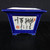 An 8-inch square ceramic Yixing bonsai pot featuring a vibrant cobalt blue glaze on its exterior. This model, 2358A, has a classic square shape with a wide, flared rim and sides that taper down toward four small, decorative feet at the base for drainage and stability. The front side of the pot highlights a recessed white rectangular panel adorned with intricate hand-painted Chinese calligraphy in bold, textured black ink. Traditional red seal markings are placed at the top right and bottom left of the panel, adding an authentic artistic touch. The pot is photographed from a front-facing perspective on a dark surface against a black background, emphasizing the contrast between the deep blue ceramic and the white hand-painted artwork. This elegant and functional bonsai container is ideal for adding a touch of traditional craftsmanship to any specimen tree display.