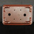 A top-down view of the underside of a 9-inch rectangular Yixing ceramic bonsai pot, highlighting its functional design. The pot is made from a classic reddish-brown, unglazed clay with a fine, matte texture. Its design features rounded corners and four ornate, scroll-shaped 'cloud' feet at each corner, providing elevation for drainage and airflow. The base contains two large, centrally-located circular drainage holes to prevent waterlogged roots. Four smaller holes are symmetrically positioned around the center, designed for threading bonsai wire to securely anchor a tree into the pot. A circular maker's mark or artist's seal is stamped clearly into the center of the base. The warm, earthy tones of the ceramic pot are set against a solid black background, emphasizing its shape and features.