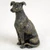 Miniature brindle Greyhound figurine in a sitting position, textured coat