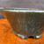Close view of the Shuho dark green glazed round pot's glaze detail
