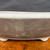 Close up of unglazed oval bonsai pot with rolled rim and dark clay finish