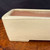 Close-up of Yamafusa rectangular bonsai pot with soft cream exterior and broad rim