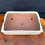 Top view of Yamafusa cream rectangle bonsai pot showing warm pink interior and drainage holes