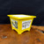 Yellow pot turned to show the full calligraphy panel and red seal