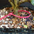 Close-up of the trunk base of a Natal Plum bonsai in a blue Yixing ceramic pot, showing bark texture, surface roots, bonsai soil, and top dressing.