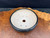 Top view of used Andy Arnault round bonsai pot showing light unglazed interior, central drainage hole, wire holes, and dark glazed rim.