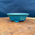 Used Koyo glazed oval bonsai pot shown from the side with vibrant turquoise blue-green glaze, flared oval shape, raised feet, and handmade Japanese bonsai container profile.