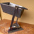 Three-quarter front view of the medium steel bonsai sculpture showing the elevated pot, geometric supports and integrated base