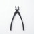 A professional-grade pair of black carbon steel bonsai knob cutters is centered vertically against a clean, solid white background. 

The tool features a pair of rounded, spherical-shaped cutting jaws at the top, which are designed to create a clean, concave-shaped incision when pruning branches. The inner sharpened edges of the blades are a contrasting polished silver-gray, while the rest of the tool has a matte black finish. 

Below the central pivot rivet, the brand name "TERUKUNI" and "JAPAN" are stamped in a subtle, sans-serif font into the metal of the right handle. A small circular stop pin is visible on the inner side of the left handle to prevent the blades from overlapping too far. 

The handles are long, slender, and elegant, gently curving outward before tapering slightly toward the smooth, rounded tips at the bottom. The entire tool displays a high-quality, minimalist aesthetic characteristic of traditional Japanese gardening equipment. The lighting is soft and even, casting subtle shadows that highlight the tool's smooth metallic texture.