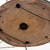 Underside of the handmade Premna bonsai pot showing the incised potter’s signature, an impressed numbered mark, drainage holes, mesh screens, tie-down wire, and unglazed clay surface.