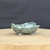 3 inch green glazed freeform bonsai pot handmade by Bruce Lenore, side view on a wooden stand, No. 172