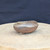 3.5 inch unglazed brown clay oval bonsai pot handmade by Bruce Lenore, turned view on the stand, No. 176