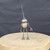 Small handcrafted found-object robot sculpture, robot 22004, full view on a wooden stool