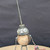 Small handcrafted found-object robot sculpture, robot 22004, closer view of the oil-can head and croquet-ball body