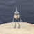 Small handcrafted found-object robot sculpture, robot 22007, full view on a wooden stool