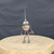 Small handcrafted found-object robot sculpture, robot 22017, full view on a wooden stool