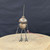 Small handcrafted found-object robot sculpture, robot 22074, full view on a wooden stool