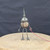 Small handcrafted found-object robot sculpture, robot 22080, full view on a wooden stool