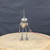Small handcrafted found-object robot sculpture, robot 22109, full view on a wooden stool