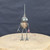 Small handcrafted found-object robot sculpture, robot 22156, full view on a wooden stool