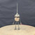 Small handcrafted found-object robot sculpture, robot 22178, full view on a wooden stool