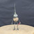 Small handcrafted found-object robot sculpture, robot 22260, full view on a wooden stool