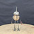 Small handcrafted found-object robot sculpture, robot 22346, full view on a wooden stool