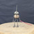 Small handcrafted found-object robot sculpture, robot 22433, full view on a wooden stool