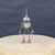 Small handcrafted found-object robot sculpture, robot 22907, full view on a wooden stool