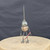 Small handcrafted found-object robot sculpture, robot 22966, full view on a wooden stool