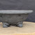 11 inch Paul Olson footed round bonsai bowl, unglazed grey clay with wide rim, No. 634, close-up of the wall