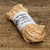 50 gram bundle of Madagascar raffia resting on a rustic wooden surface